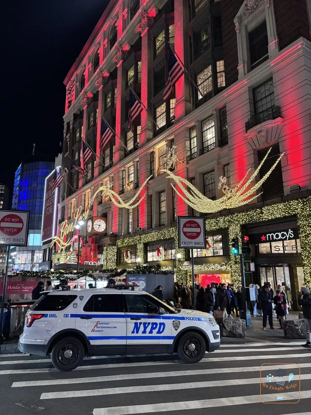 La façade de Macy's Herald Square décorée pour Noël avec une voiture du NYPD