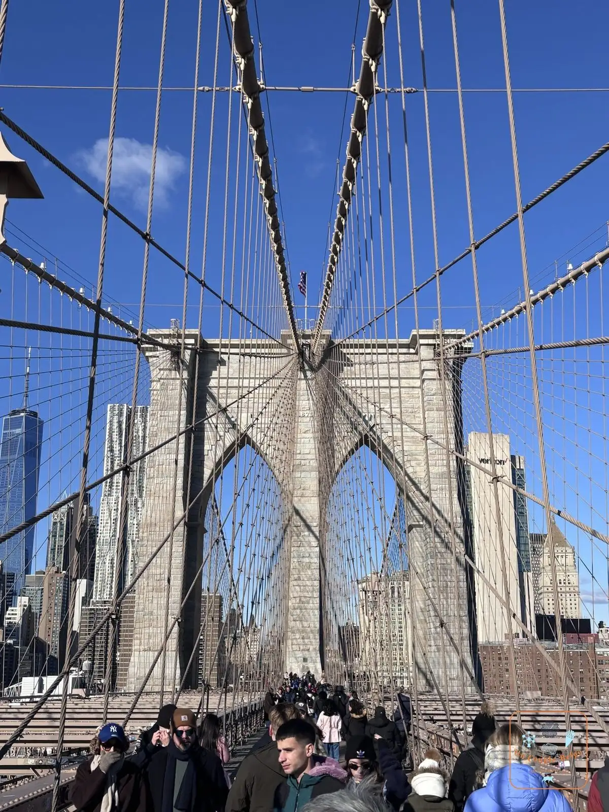 Les câbles et les arches gothiques du pont de Brooklyn avec la foule
