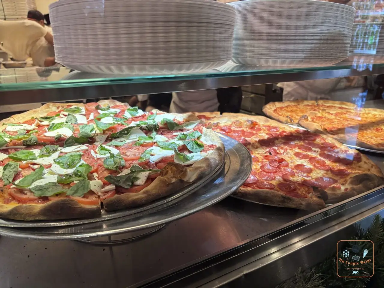 Pizzas margherita et pepperoni derrière la vitrine de Joe's Pizza